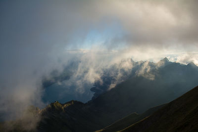 Scenic view of mountains against cloudy sky