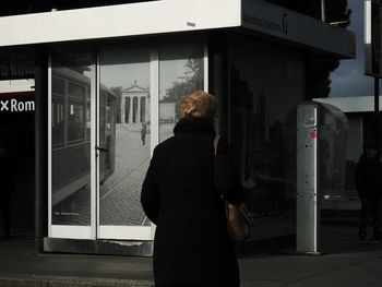 Rear view of woman standing in bus