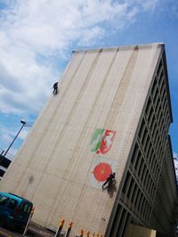 Low angle view of flag against sky in city