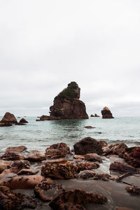 Rocks on beach against sky