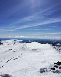 View of snow covered landscape against cloudy sky