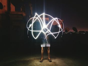 Man playing with light painting at night