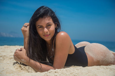 Portrait of woman at beach against sky