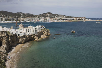 Aerial view of sea and cityscape against sky