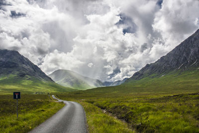Scenic view of mountain road against cloudy sky