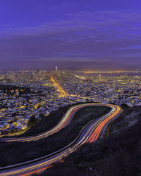 High angle view of illuminated city against sky at dusk