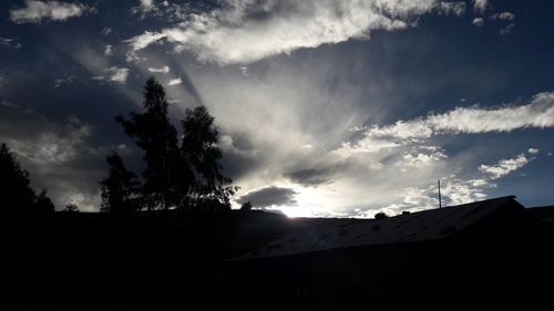 Low angle view of silhouette trees against sky