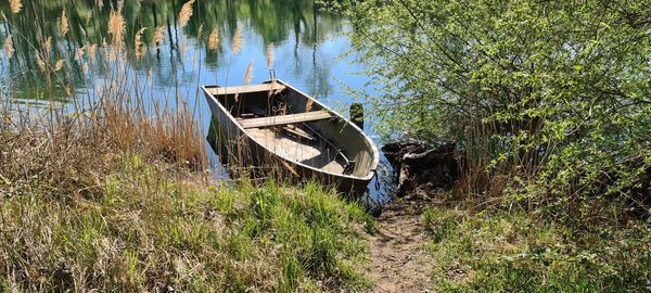 Abandoned boat moored on shore