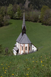 Traditional building by trees on field