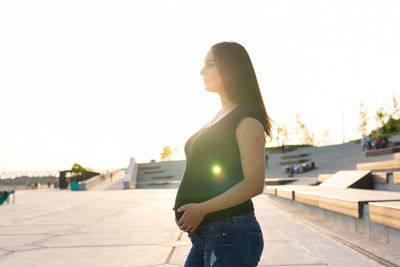 Side view of woman standing against sky