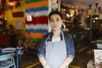 Portrait of confident male restaurant owner wearing apron