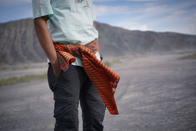 Rear view of woman walking on mountain against sky