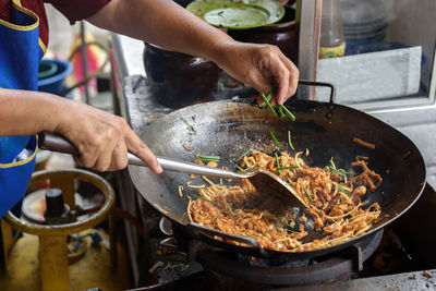 Cropped hands of man preparing food in kitchen