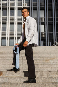 Man wearing fully unbuttoned shirt while standing on steps