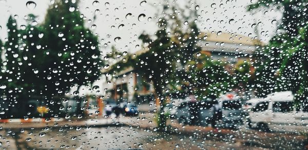 City seen through wet glass window during rainy season