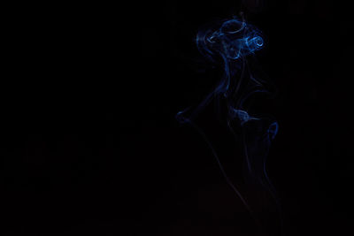 Close-up of smoke moving against black background