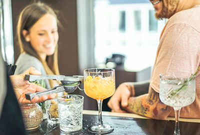 Close-up of bartender making drinks for people