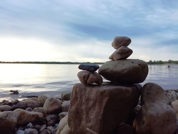 Close-up of pebbles on beach against sky