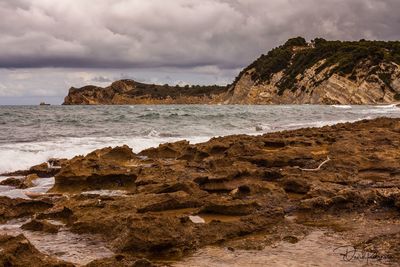 Rocks on beach against sky