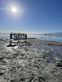 Text on beach against clear sky