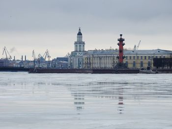 Buildings at waterfront against sky
