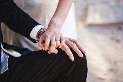 Midsection of couple holding hands