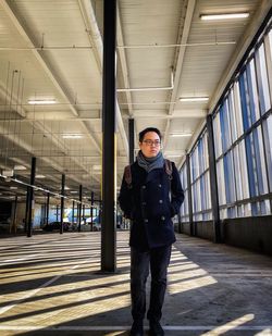 Portrait of young woman standing in building