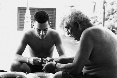 Men sitting on cutting board