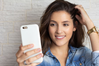 Portrait of smiling young woman using mobile phone