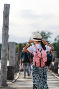 Rear view of woman standing against sky in city