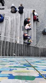 High angle view of people sitting by water