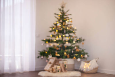 Christmas interior. the christmas tree with gift boxes is blurry.