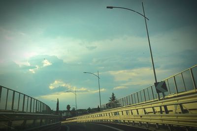 Bridge over river against cloudy sky