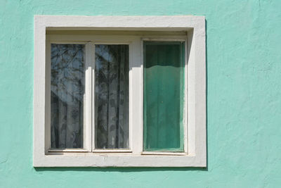 Full frame shot of window on green wall of building