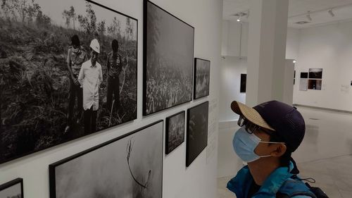 A male visitor is looking at the photo exhibition