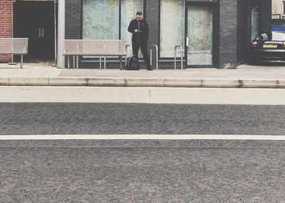 Side view of man walking on street in city