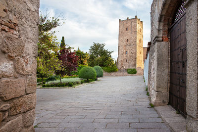 View of alley amidst buildings against sky