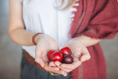 Midsection of woman holding plums