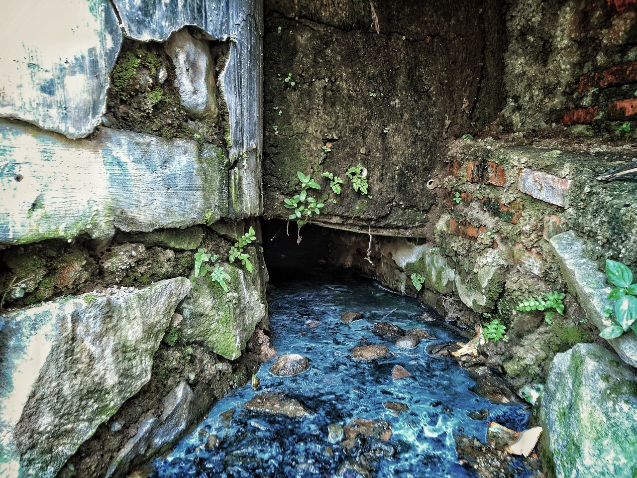 HIGH ANGLE VIEW OF WATER FLOWING IN OLD WALL