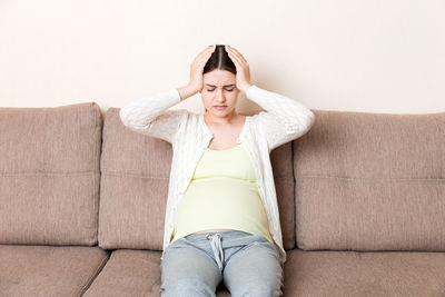 Young woman sitting on sofa at home