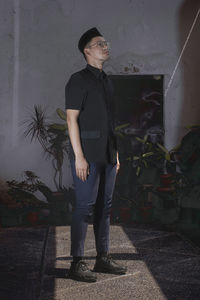 Full length of man standing against wall