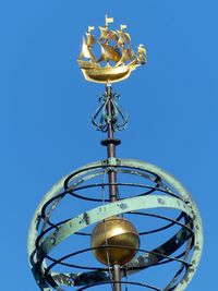 Low angle view of electric lamp against clear blue sky