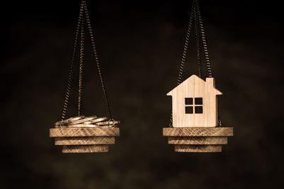 Low angle view of cross hanging on rope against building