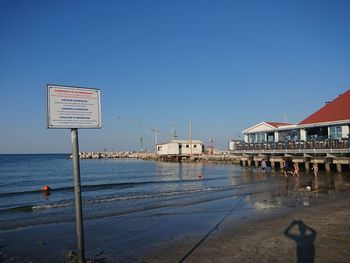 Scenic view of beach against clear blue sky