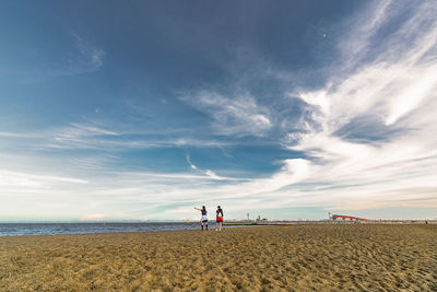 People on beach against sky