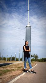 Full length portrait of young man standing against sky