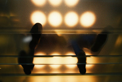 Low section of people walking on illuminated floor