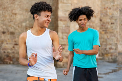 Afro latin male friends dancing in the street