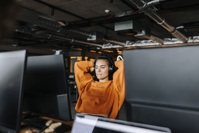Tired female entrepreneur taking break while sitting at desk in office