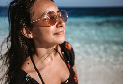 Close-up of young woman wearing sunglasses at beach